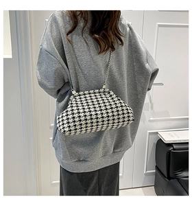 Detail of houndstooth cloud bag featuring vintage texture and metallic chain strap