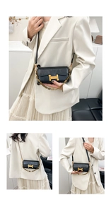 Détail du sac bandoulière en cuir noir avec boucle H dorée sur un blazer blanc chic