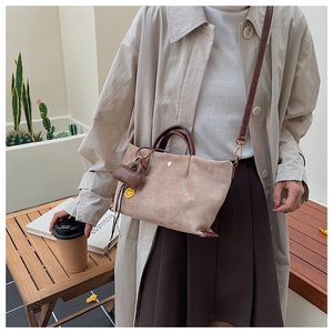 Vue détaillée du sac en daim mauve avec poignées marron et charmant pendentif sourire