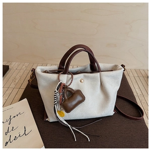 Détail d'un sac cabas en toile minimaliste avec finitions en cuir brun et corde tressée
