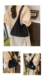 Détail d'un grand sac hobo en daim noir avec pendentif rond pour le trajet quotidien