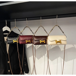 Détail du fermoir métallique doré en forme de H sur quatre sacs à main en cuir coloré