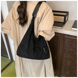 Détail d'un grand sac cabas hobo en daim noir montrant sa texture douce et son volume généreux