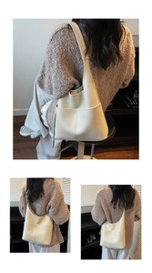 Close-up of creamy white pebble grain leather bucket bag with large front pocket