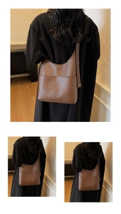 Detail view of brown pebbled leather bucket bag with adjustable strap for women