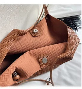 Detailed top view of brown woven tote bag interior with magnetic closure and inner lining