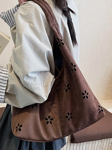 Dark brown suede hobo bag with laser-cut flower patterns for autumn street style