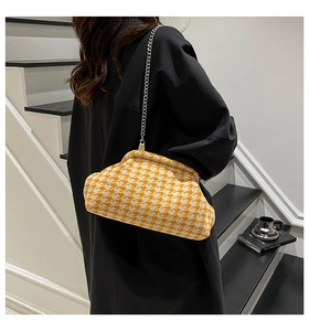 Detail showing the orange houndstooth weave pattern and silver chain on the cloud bag