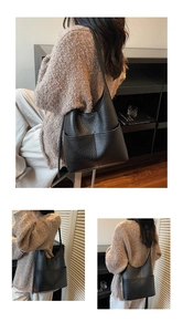 Detail of black pebbled leather bucket bag showing soft texture and stitching