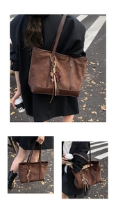 Dettaglio della borsa tote in pelle scamosciata marrone con ciondoli e logo in metallo