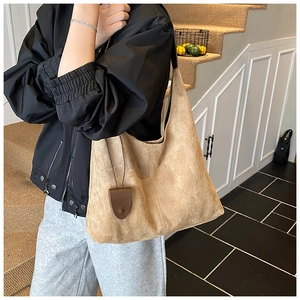 Détail du grand sac cabas en daim camel avec pendentif triangulaire en cuir