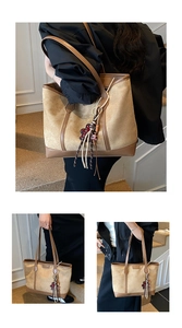 Dettaglio della borsa tote kaki e marrone con ciondolo a frange e logo in metallo