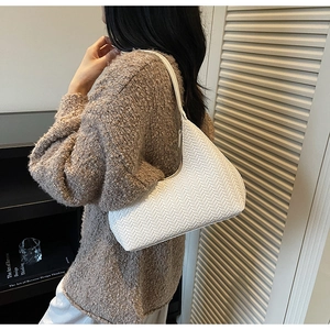 Vue détaillée de la texture en cuir tissé du sac à bandoulière blanc en demi-lune