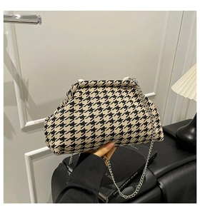 Detail of houndstooth cloud bag with silver chain strap and metal frame closure