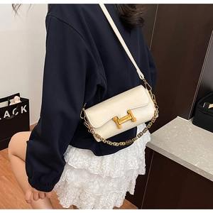 Détail du sac en cuir blanc cassé avec fermoir en H doré et chaîne en métal élégante