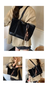 Dettaglio della borsa tote nera con logo in lamina d'oro e ciondolo con nappe intrecciate