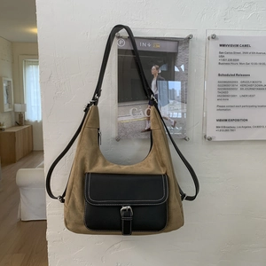 Detailed close-up of retro camel suede hobo bag with black leather pocket and metal buckle