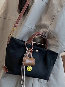 Sac bandoulière noir minimaliste avec anses marron et charmant visage souriant