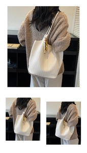 Detail of white woven tote bag with woven faux leather texture and colorful wooden beads