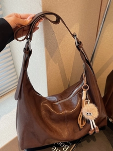 Vintage dark brown hobo bag in glossy leather with a cute plush monster charm