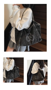 Detail of grey denim tote bag showing the silver metal chain strap and abstract embroidery