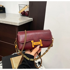 Détail du sac bandoulière rouge vin avec boucle H dorée et bandoulière en chaîne