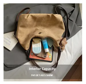 Detail view of the spacious inner compartment of the tan faux suede tote bag with magnetic snap