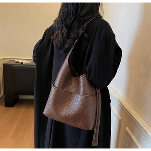 Detail of brown litchi pattern leather tote bag with two symmetric front pockets