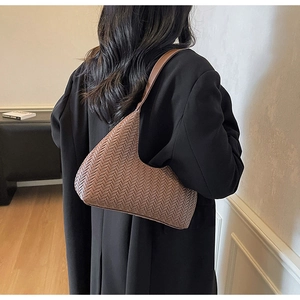 Gros plan sur la texture en cuir tressé marron d'un sac hobo rétro élégant pour femme