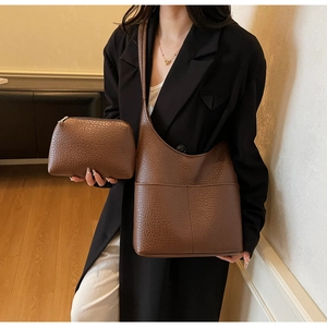 Detail of brown litchi pattern leather tote bag with matching zippered pouch set