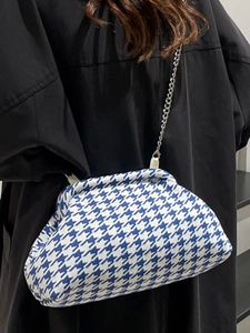 Blue and white houndstooth cloud clutch bag with silver metal chain strap on model