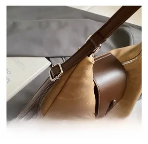 Detail of adjustable brown leather strap and khaki canvas flap on minimalist tote bag