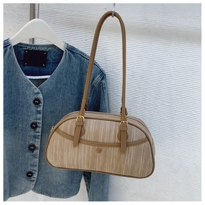 Détail du sac bandoulière kaki avec boucles dorées et texture à rayures fines