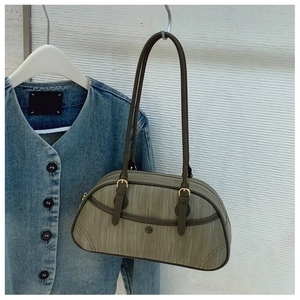 Détail du sac sous le bras vert olive avec texture bois verticale et boucle dorée