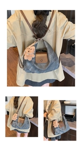 Detail view of charcoal canvas tote bag with brown leather accents and plush bear charm