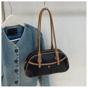 Détail du sac tissé noir avec bordure en cuir marron et boucle en métal doré chic