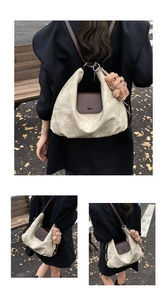 Detail of pleated tote bag with dark brown leather flap and bear charm in street style