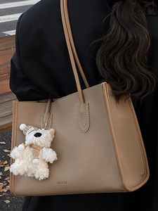 Chic khaki pebbled leather tote bag with cute plush bear charm for daily commuting style