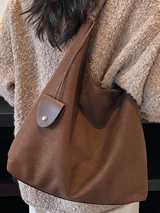 Brown faux suede tote bag with mini charm pouch shown on model in a cozy knit sweater