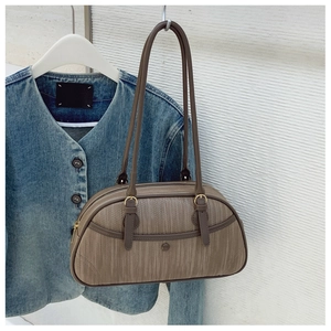 Détails de la texture côtelée du sac baguette marron avec anneaux dorés élégants