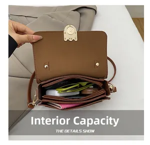 Detail view of the brown shoulder bag with multiple interior storage compartments