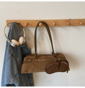 Κοντινό πλάνο χακί κυλινδρικής τσάντας nubuck με δερμάτινα λουράκια και θήκη