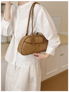 Détail de la texture tressée du sac bowling en cuir caramel avec clous et fermeture éclair