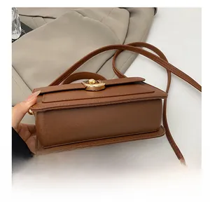 Detail view of the wear-resistant base and leather texture on a stylish brown crossbody bag