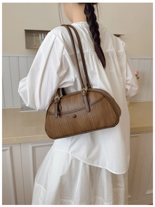Détail de la texture tressée marron et boucle en bronze d'un sac à bandoulière rétro