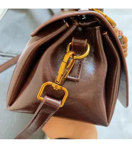 Detail of vintage bronze spring hook and coffee litchi grain leather shoulder bag