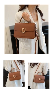Detail of lychee pattern leather handbag with gold U-shaped buckle and top handle