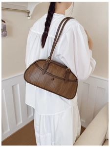 Sac baguette marron en cuir PU tressé porté par un mannequin dans un style épuré