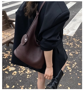 Detail of dark brown leather hobo bag with unique knotted strap and round coin purse