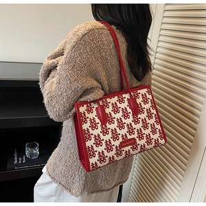 Close-up of festive red double happiness jacquard fabric on stylish tote bag with leather trim